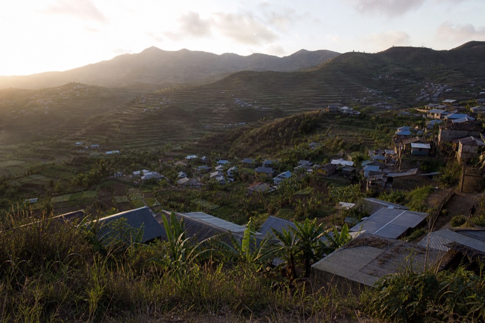 A hillside village of tin-roofed houses below the park boundary, banana groves and small terraced fields packed between the buildings